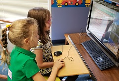 girls play on computer together