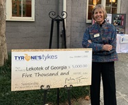 Lekotek Leader accepts check with Lekotek family